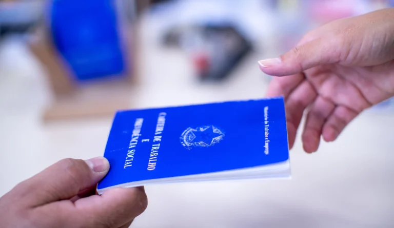 Homens e mulheres consultando listas de vagas de emprego e computadores, simbolizando a busca por trabalho no Alto Tietê.