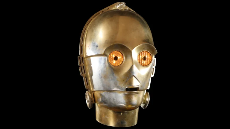 Cabeça de C-3PO de Star Wars, dourada com olhos acesos, em exposição para leilão
