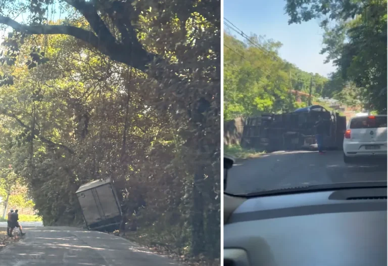 Caminhão com avarias leves após acidente em curva da Serra da Tiririca, com placa de proibição para veículos pesados.