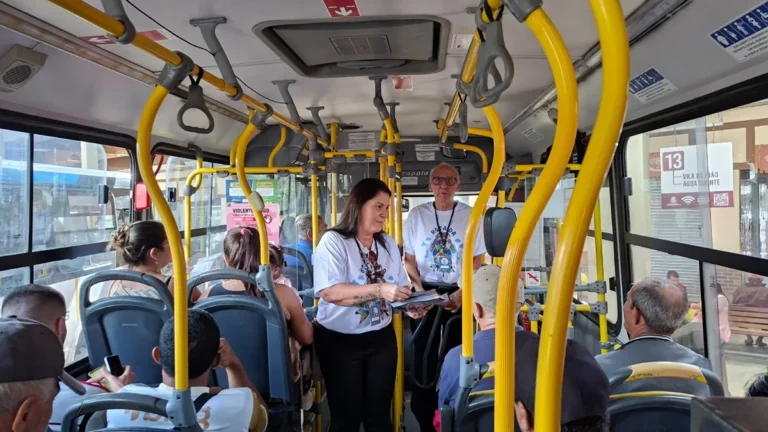 Pessoas em ônibus de Teresópolis participando da campanha de conscientização sobre autismo, com foco em empatia e inclusão no transporte público.
