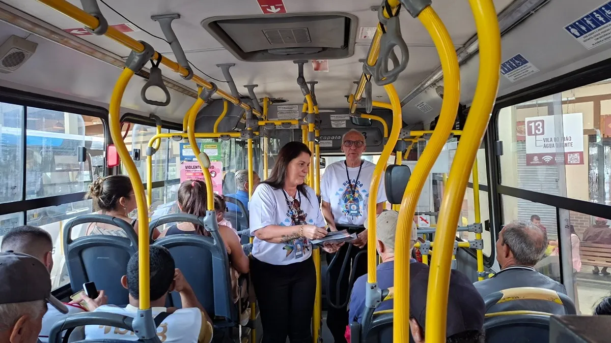 Pessoas em ônibus de Teresópolis participando da campanha de conscientização sobre autismo, com foco em empatia e inclusão no transporte público.