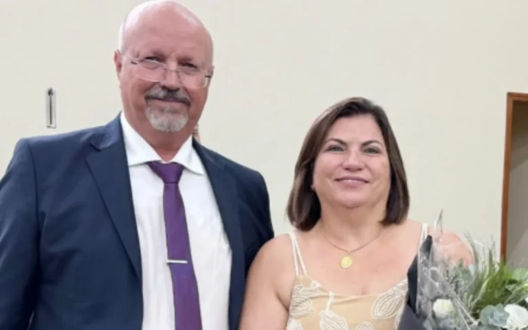 Vista aérea da cidade de Vista Alegre do Alto em luto, com bandeiras a meio mastro e pessoas reunidas para o velório do prefeito e primeira-dama.