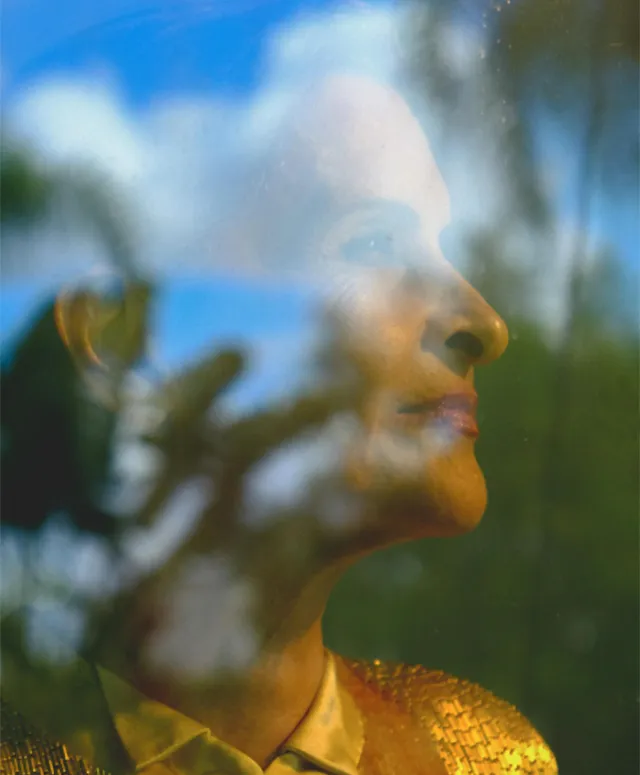 Homem ou mulher concentrado(a) escrevendo uma crítica de álbum, rodeado(a) por símbolos musicais e tecnologia.