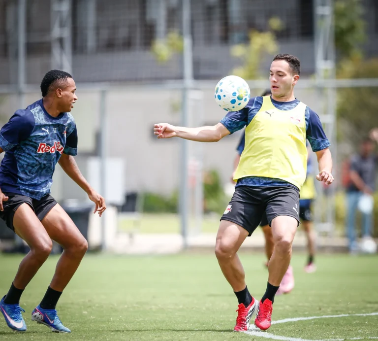 Jogadores do Bragantino treinando em campo, com o técnico Vagner Mancini observando, preparando-se para o jogo contra o Flamengo