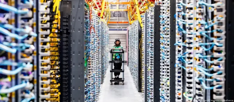 Um data center com servidores iluminados e uma usina elétrica ao fundo, mostrando a Demanda de Energia da IA.