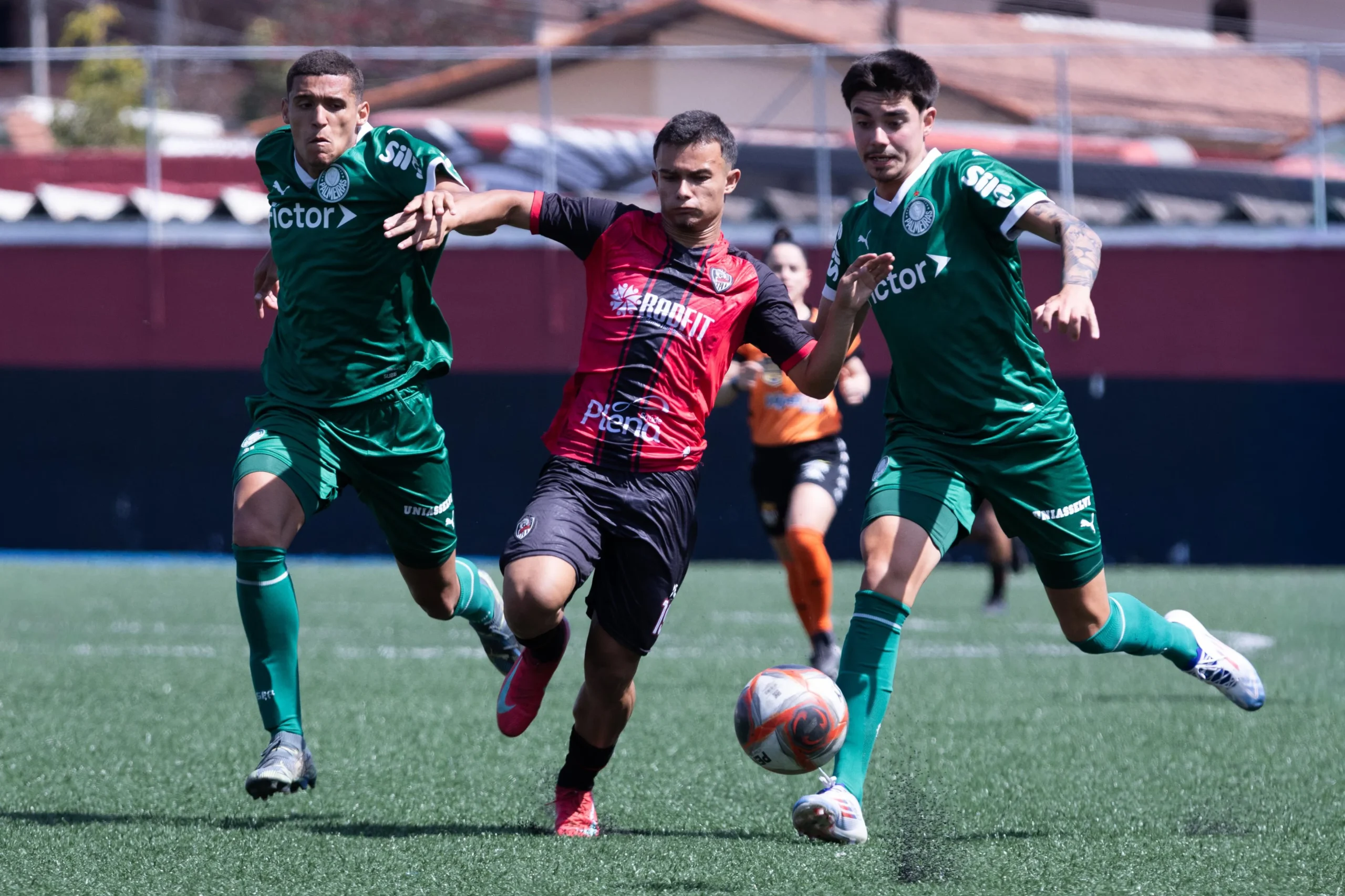 Jogadores de futebol Sub-15 e Sub-17 disputando bola em campo durante o Campeonato Paulista