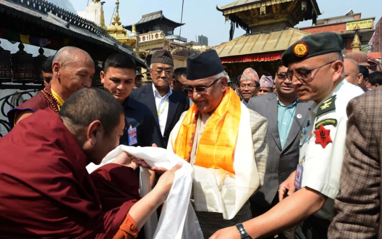 Foto do ex-premiê do Nepal, KP Sharma Oli, sob custódia policial, com manifestações ao fundo