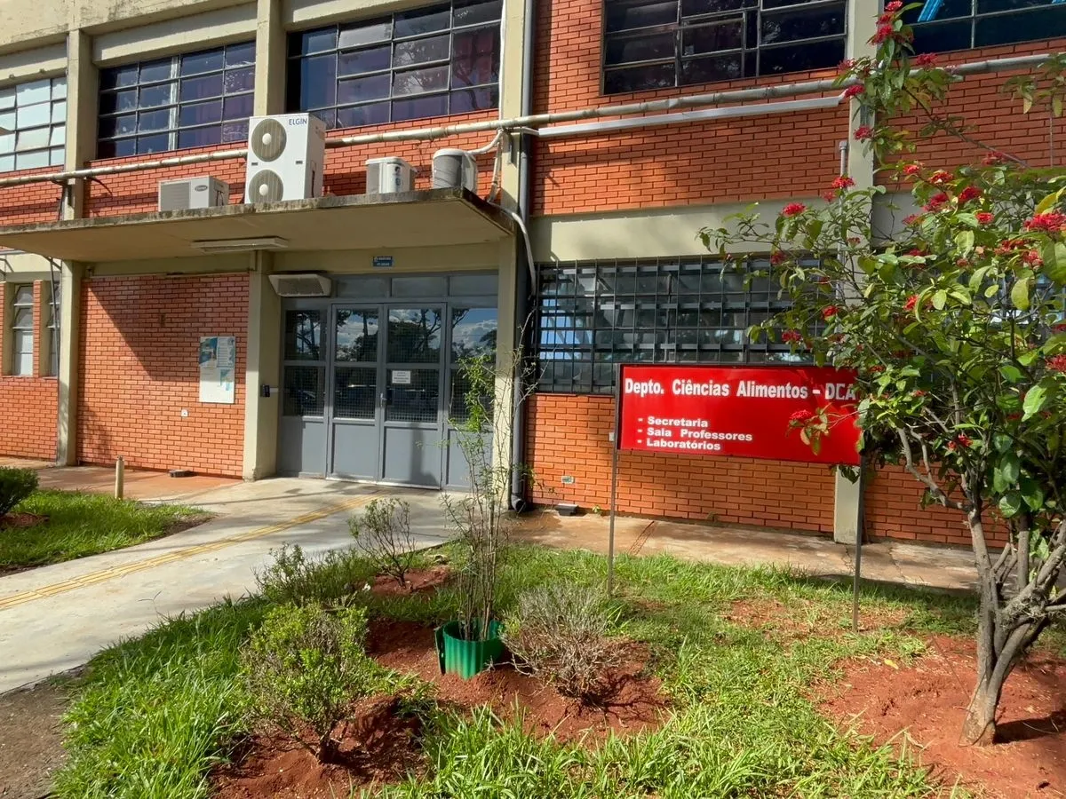 Cientista em laboratório com frasco de vírus e símbolo de risco biológico