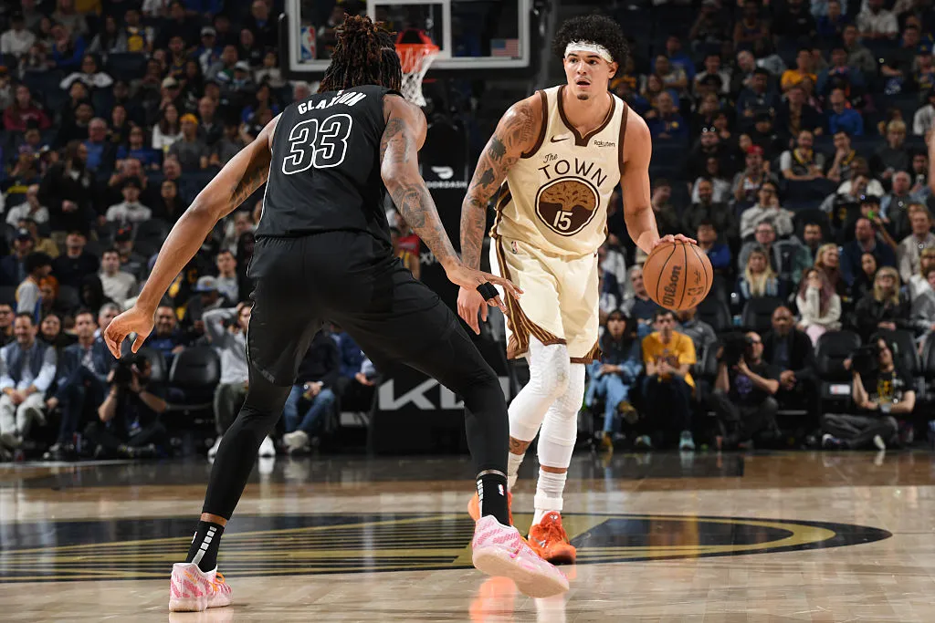 Gui Santos, jogador do Golden State Warriors, arremessando a bola durante um jogo da NBA.
