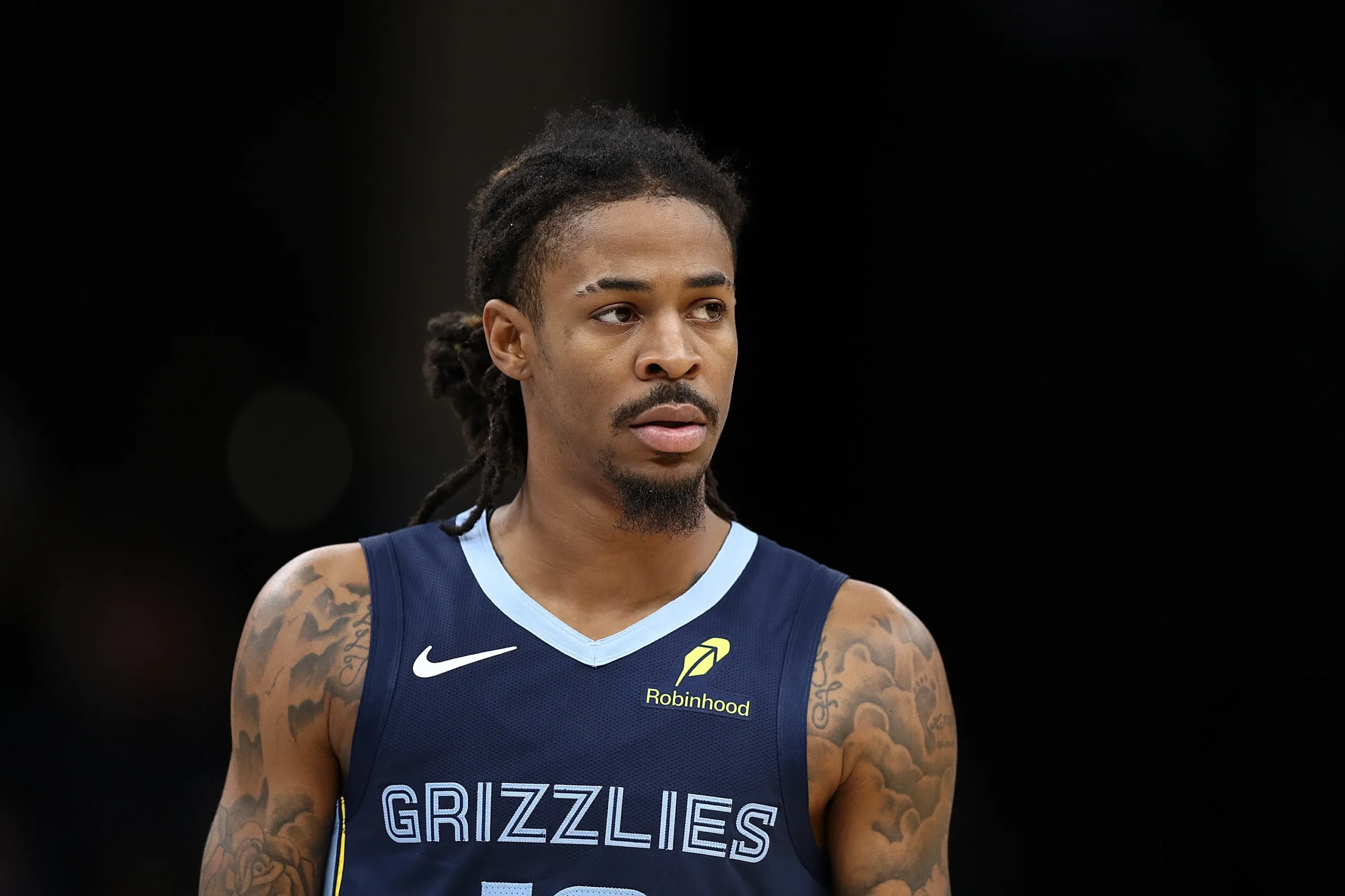 Foto de Ja Morant em quadra com uniforme dos Grizzlies e foco no cotovelo esquerdo lesionado