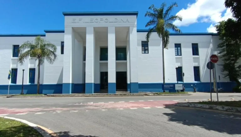 Balão da justiça e documentos oficiais sobre uma mesa, simbolizando a liberação do concurso da Educação em Campos pela decisão judicial