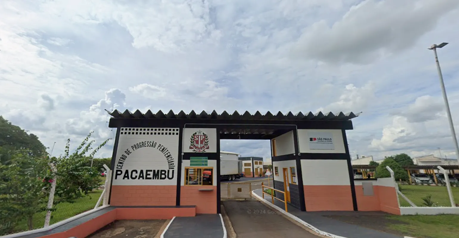Vista de um portão de prisão com grades e alambrado, representando o tema da saída temporária de presos no estado de São Paulo.