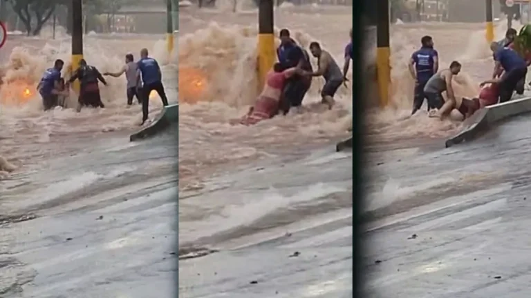 Carro coberto pela água em alagamento na Avenida Nações Unidas, Bauru, com pessoas em ação de resgate.