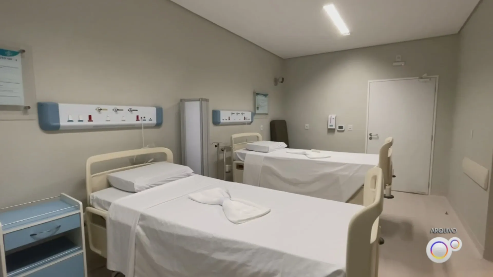 Leitos psiquiátricos em hospital geral, sinalização de unidade de saúde mental, corredor limpo e iluminado.