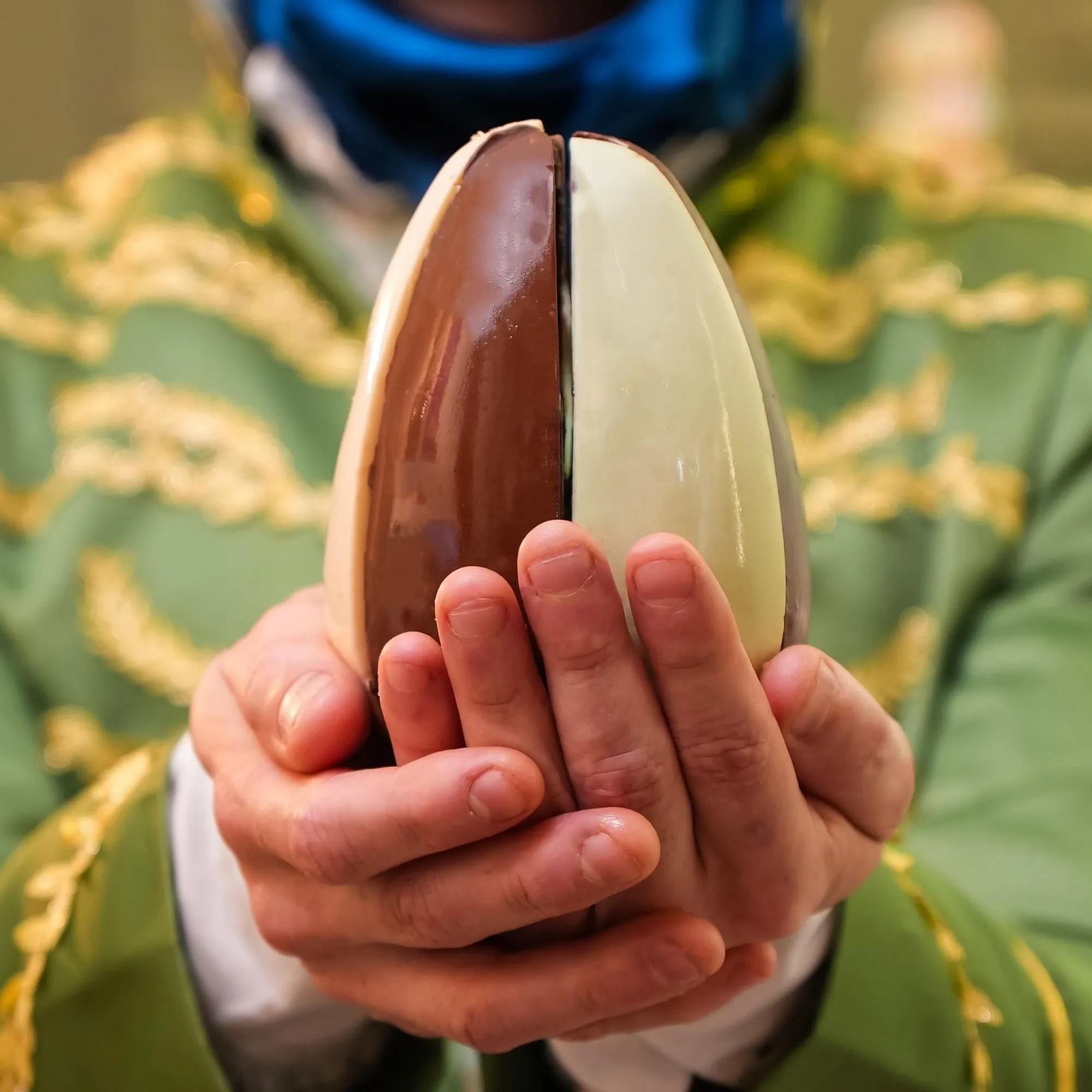 Ovo de Páscoa tradicional pintado ao lado de um ovo de chocolate, simbolizando a história e evolução da Páscoa.