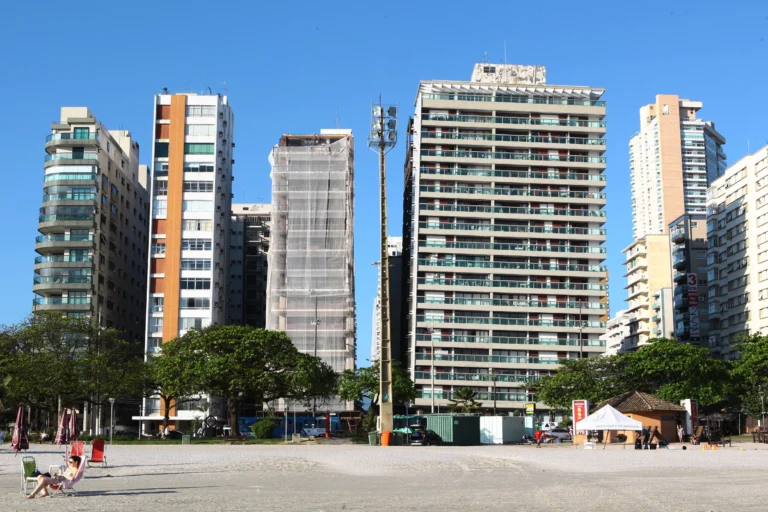 Foto de prédios na orla de Santos com inclinação visível, mostrando a arquitetura e o cenário costeiro.