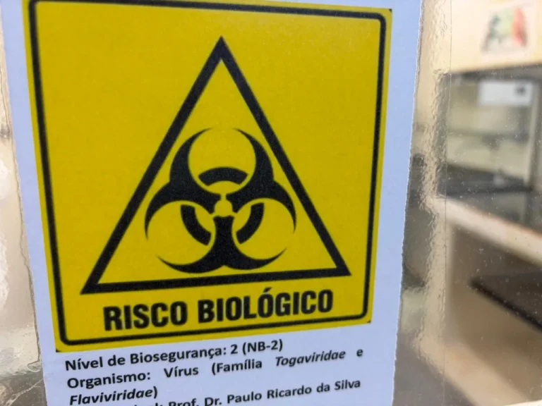 Pesquisador com traje de proteção em laboratório, estudando vírus