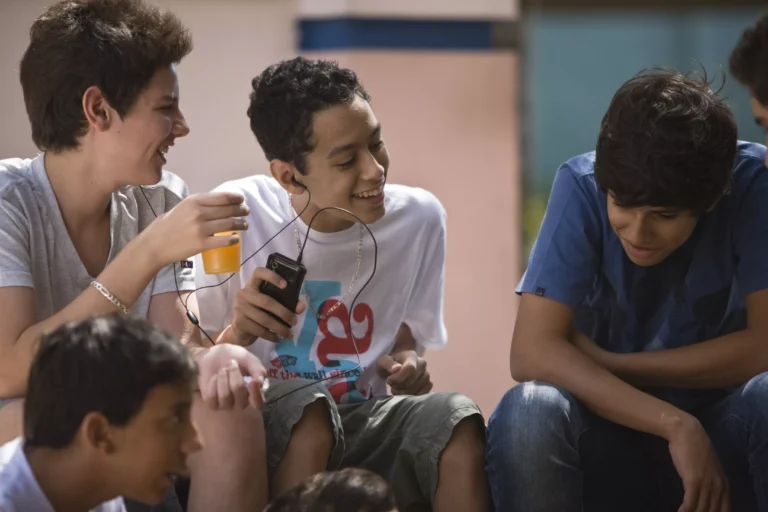 Grupo de adolescentes brasileiros em escola, refletindo sobre a adolescência brasileira