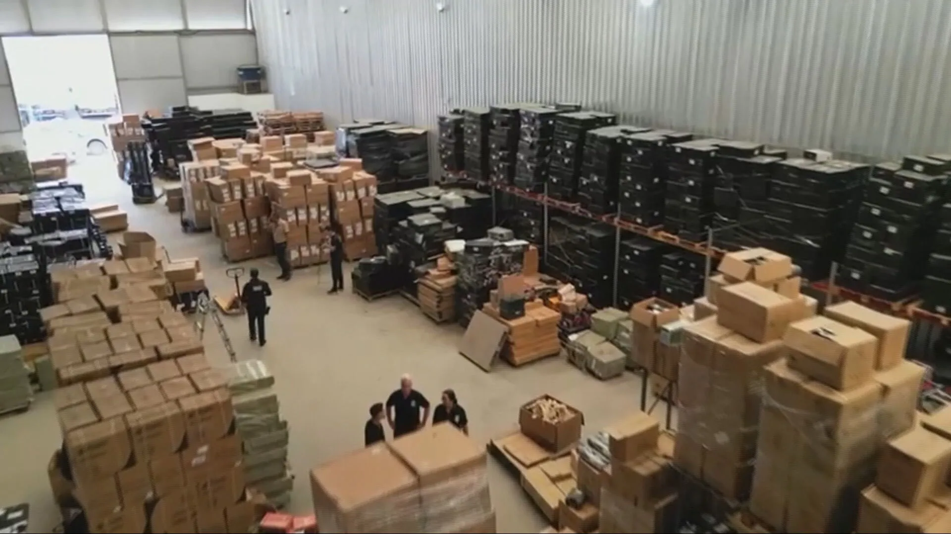 Fiscalização da Receita Federal em galpão de produtos contrabandeados devido à sonegação de impostos.