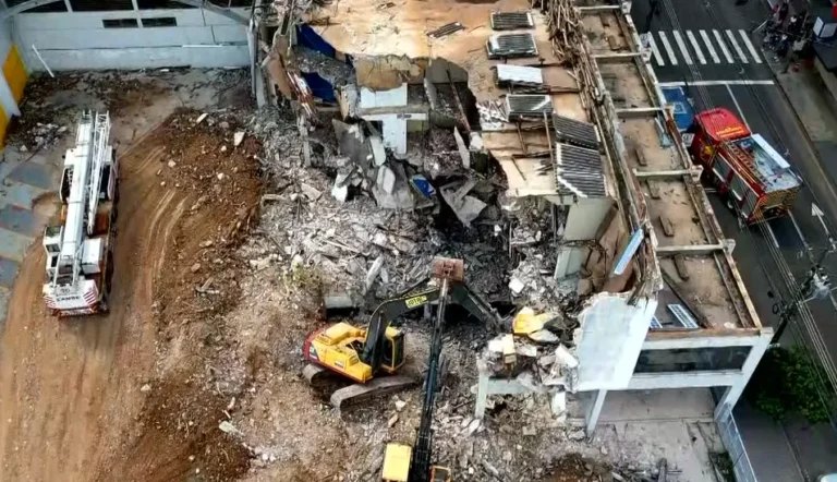 Canteiro de obras em Londrina com retroescavadeira após acidente fatal.