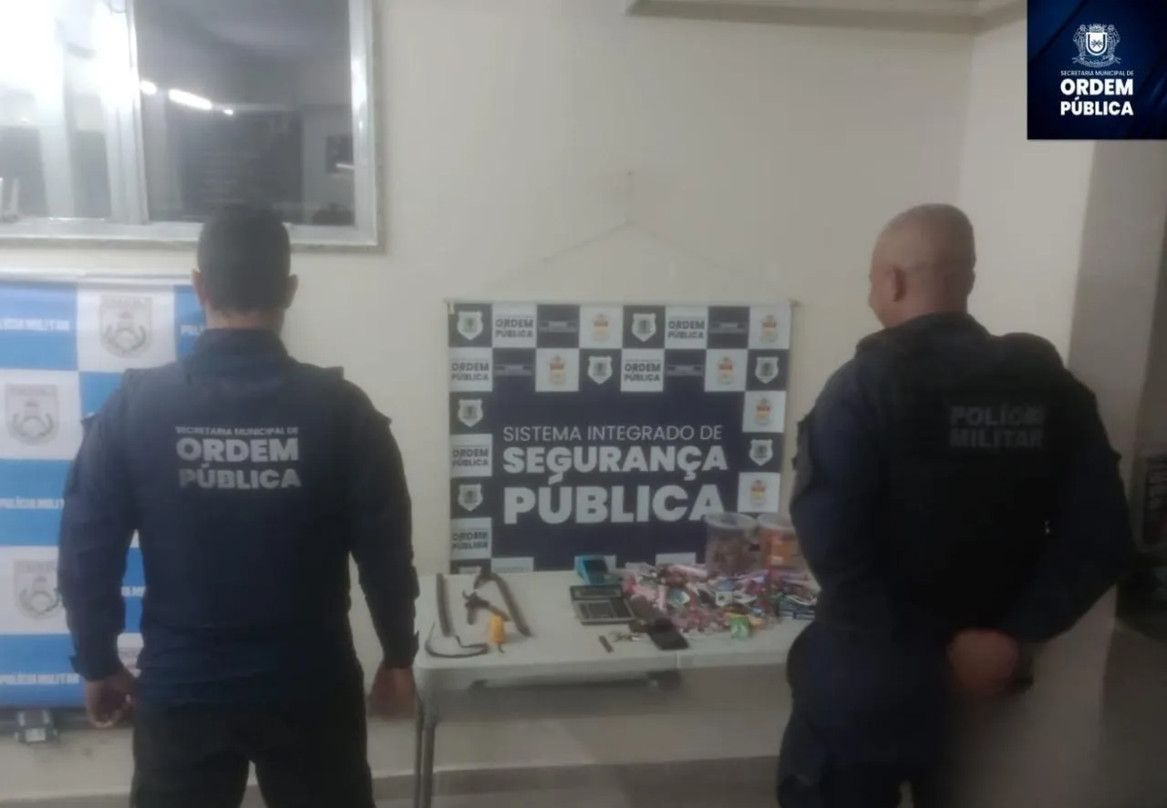 Dois policiais prendendo um homem e uma mulher em frente a uma loja em Volta Redonda