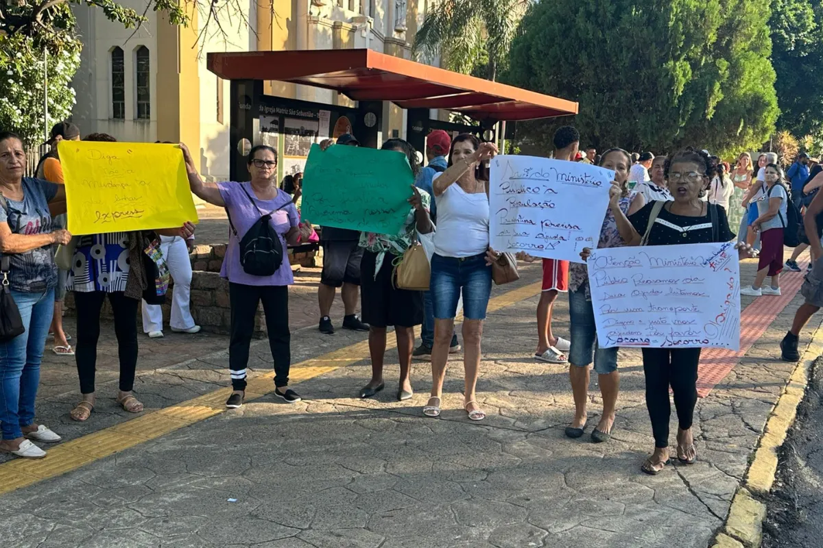 Pessoas com cartazes protestam contra o novo sistema de ônibus em Presidente Prudente