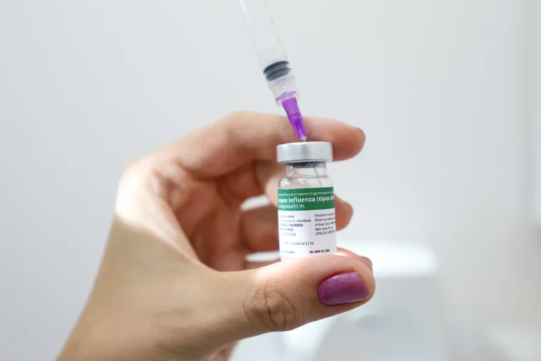 Vacinação contra gripe sendo aplicada por profissional de saúde