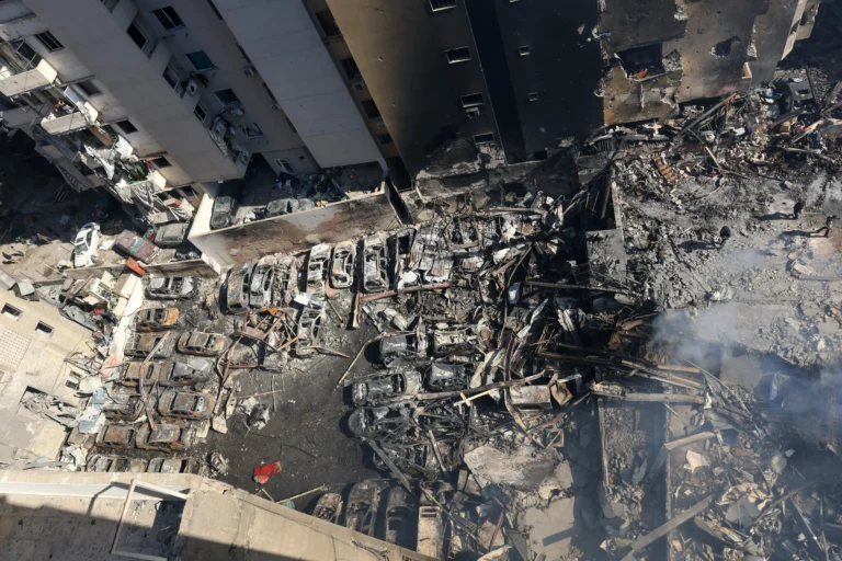 Ruínas de edifícios em Beirute após bombardeio israelense, equipes de resgate trabalhando.