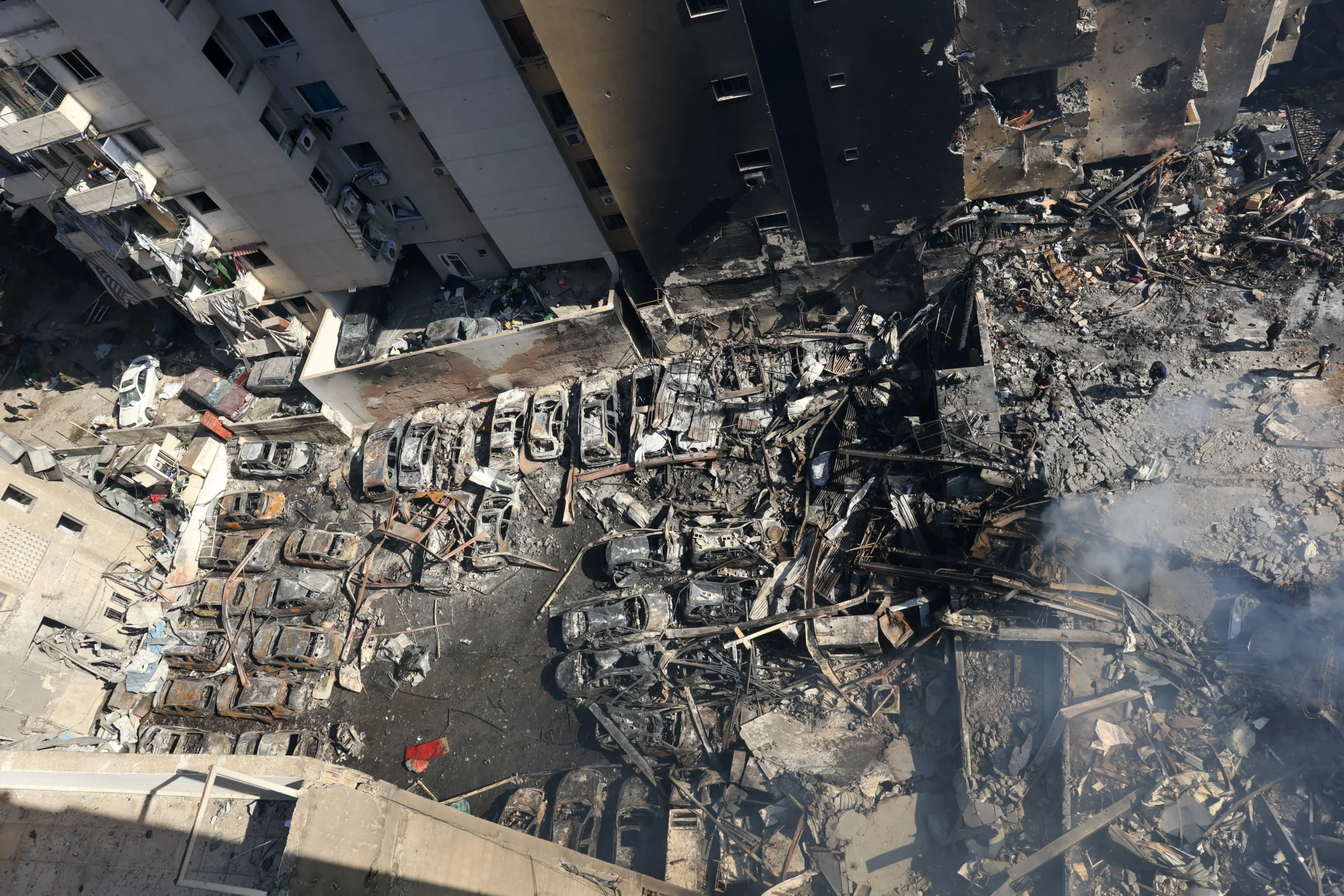 Ruínas de edifícios em Beirute após bombardeio israelense, equipes de resgate trabalhando.