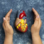 Mulher sorrindo, praticando atividade física, com um coração estilizado ao fundo, representando a relação entre saúde do coração e câncer.