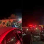 Cena de acidente multi-carro na RJ-216 com veículo destruído e luzes de emergência