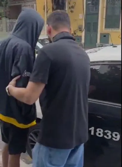 Algemas e distintivo da polícia ao lado de notebook em cena de investigação de crimes online envolvendo adolescente.