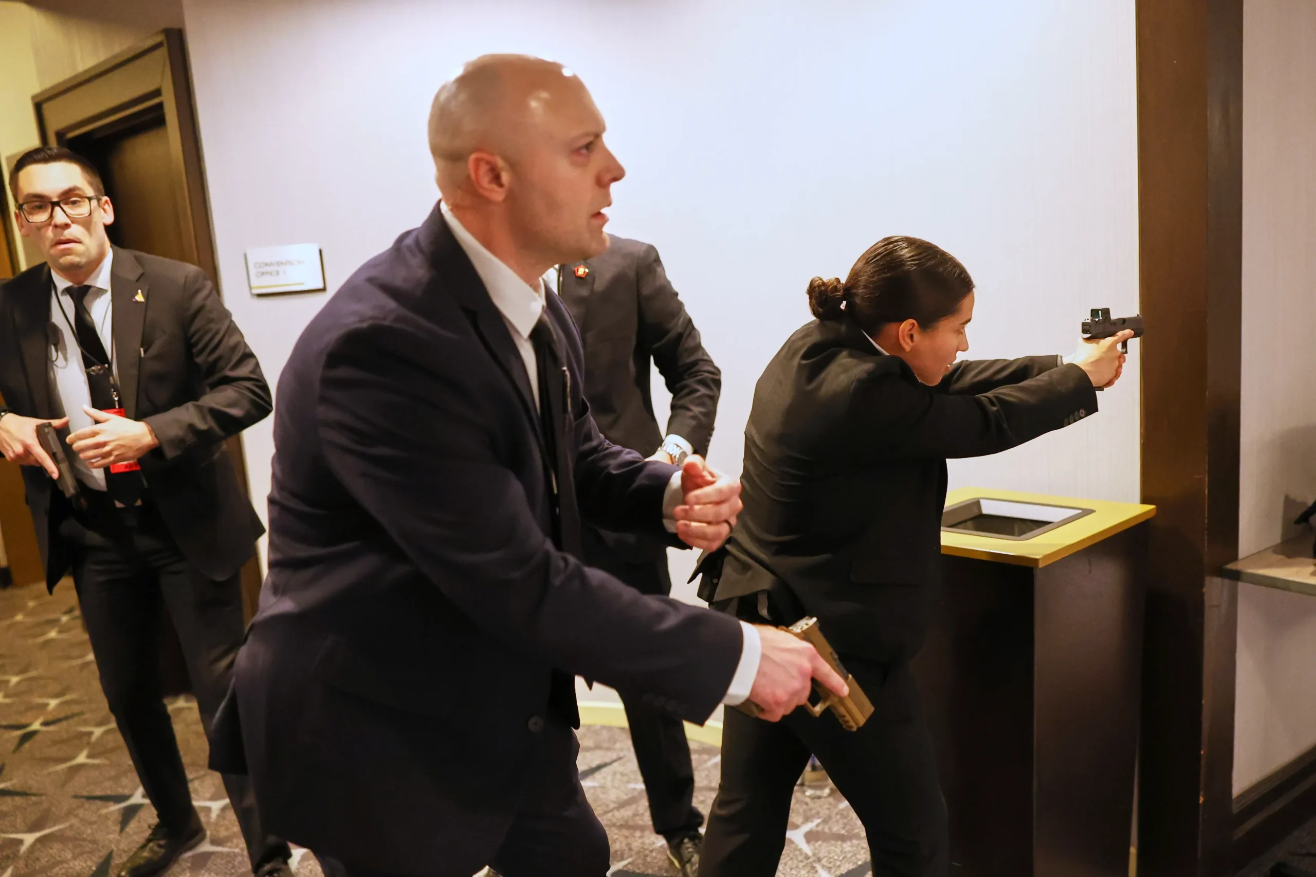 Agentes do Serviço Secreto detendo um homem no chão durante um incidente de tiros em um jantar com Donald Trump