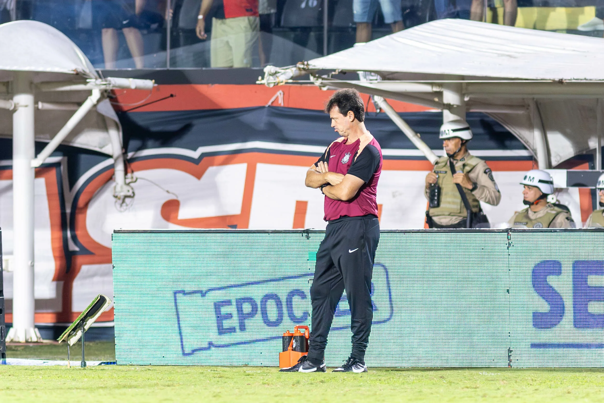 Jogadores do Corinthians em campo durante jogo do Brasileirão, com a bola em disputa e torcida ao fundo.