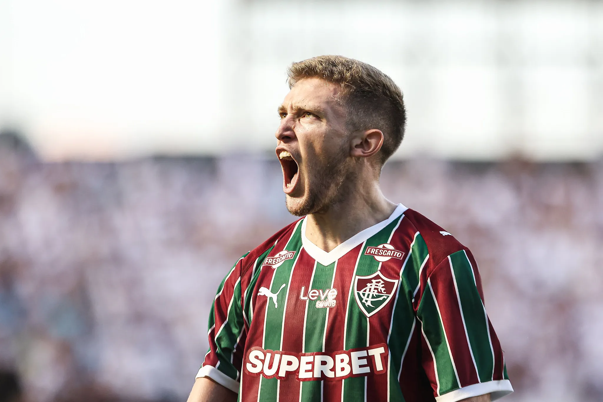 Jogadores do Fluminense comemorando um gol em campo, com o placar de 3 a 2 ao fundo, durante partida contra o Santos.