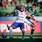 Jogadores do Guarani e Itabaiana em campo, com torcida ao fundo no Brinco de Ouro