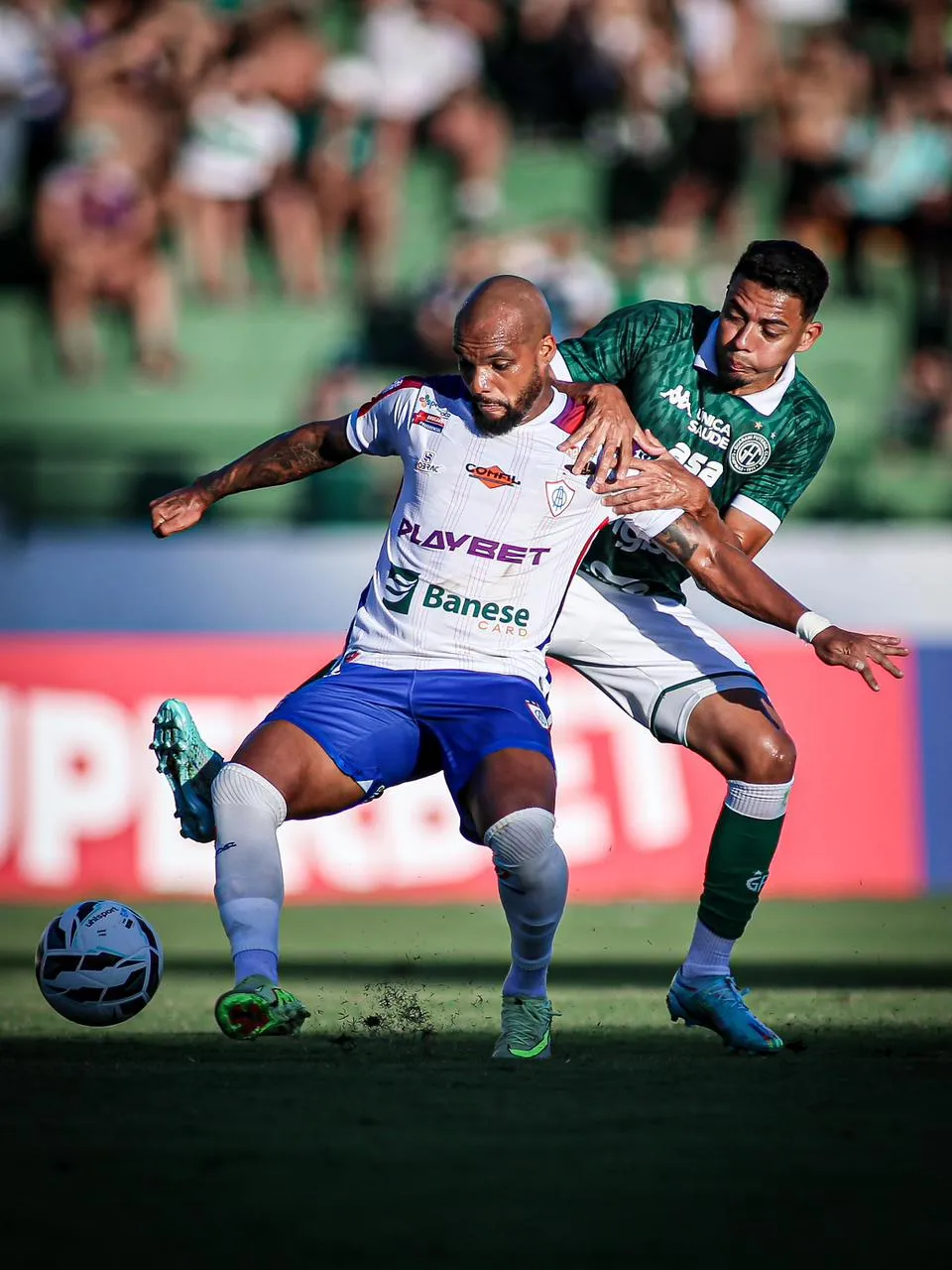Jogadores do Guarani e Itabaiana em campo, com torcida ao fundo no Brinco de Ouro