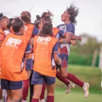 Tânia Maranhão, jogadora de futebol de 51 anos, comemorando gol em campo