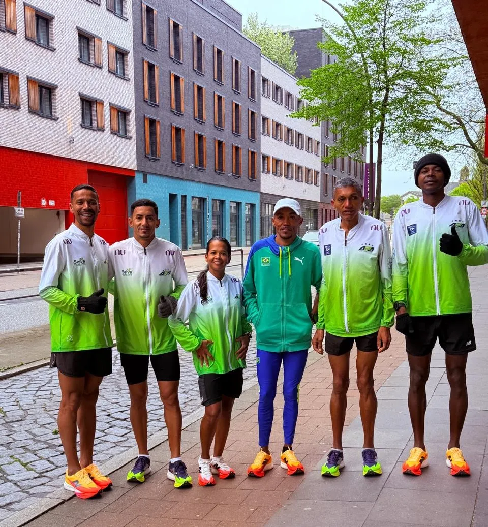 Corredores da APA Petrolina treinando em parque de Hamburgo antes de maratona internacional, incluindo atleta paralímpico.