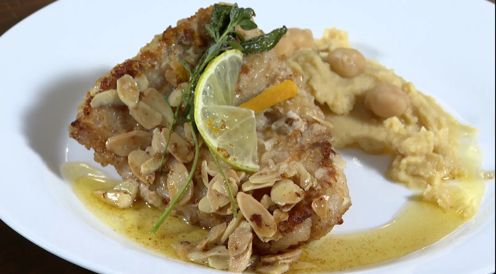 Prato de filé de pescada na manteiga com amêndoas e purê de grão-de-bico