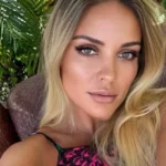 Atleta nadando em lago durante prova de Ironman no Texas, com barcos de segurança e outros competidores ao fundo.