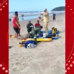 Avô idoso resgatando neto em mar agitado, com ondas fortes e guarda-vidas ao fundo.