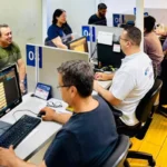 Pessoas diversas em frente a um mapa-múndi, ilustrando a crise global de empregos e a necessidade de cooperação internacional para criar oportunidades.