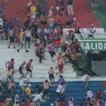 Confronto de torcedores e polícia no estádio durante clássico paraguaio