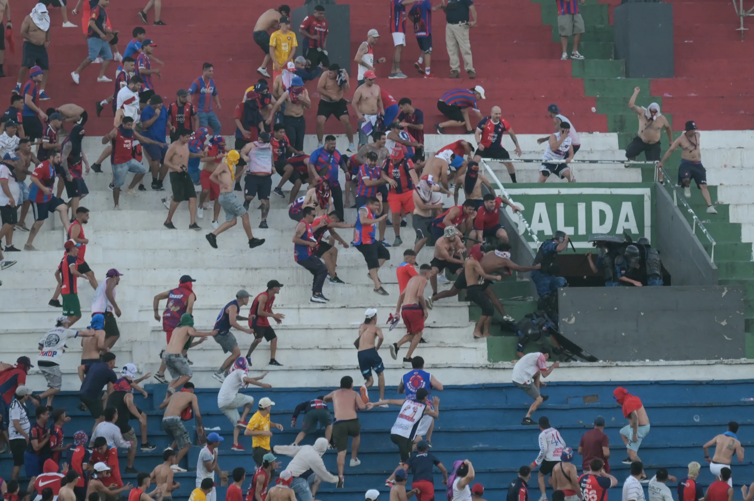 Confronto de torcedores e polícia no estádio durante clássico paraguaio
