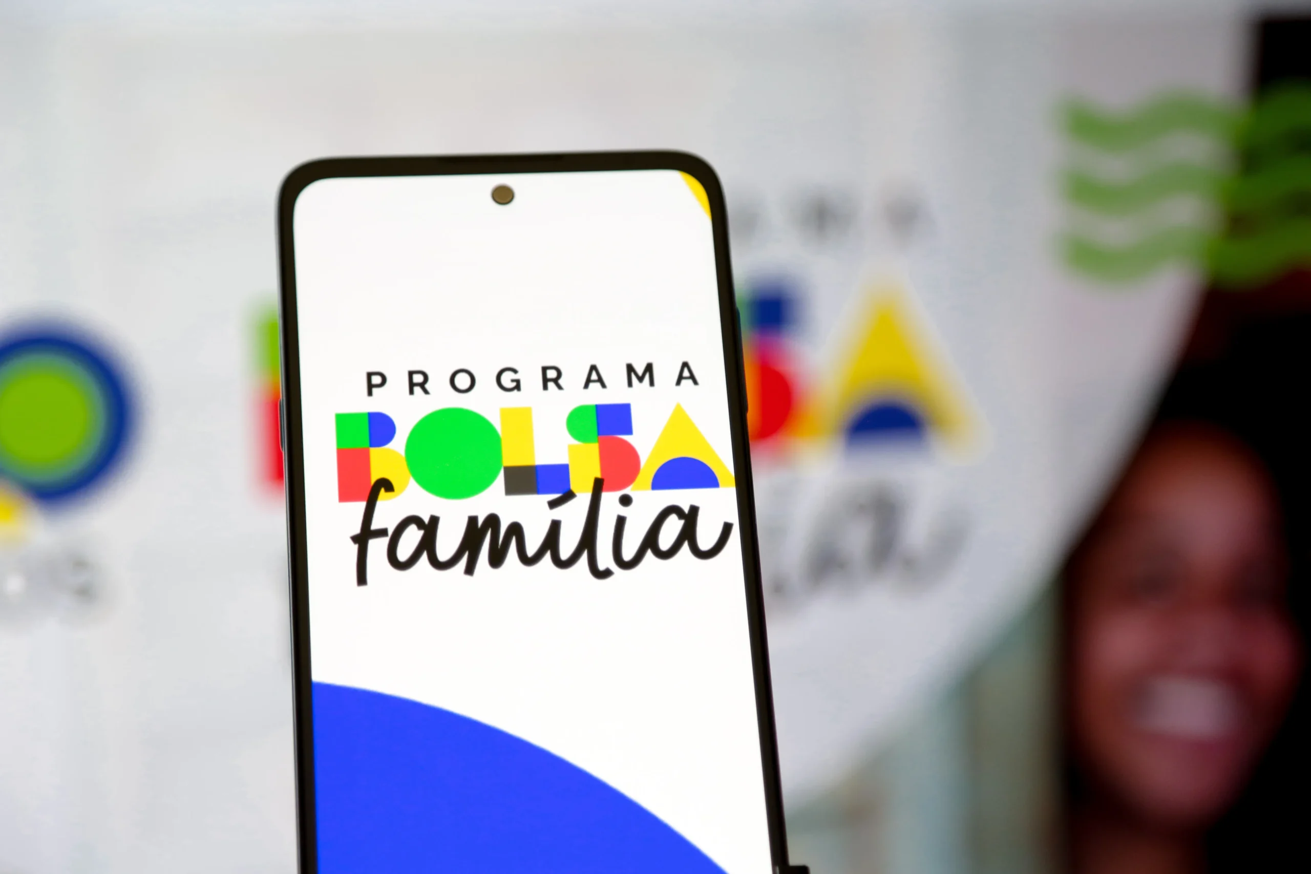 Família feliz checando datas do Bolsa Família 2026 no celular