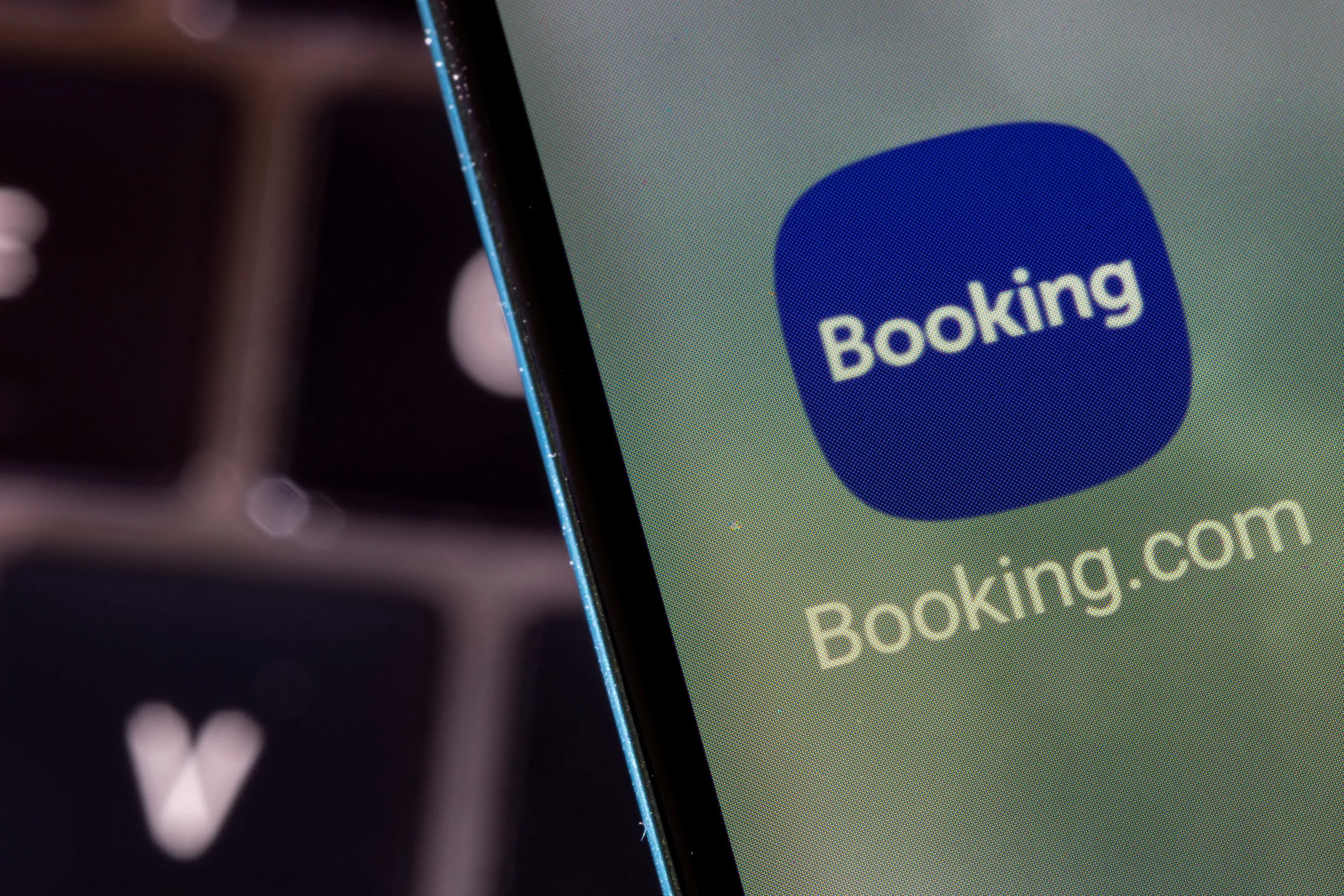 Cadeado digital sobre tela de computador com dados da Booking.com e código de programação