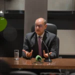 Mãos organizando documentos e eliminando papéis desnecessários em um ambiente governamental, representando as exonerações RJ e a busca por transparência.