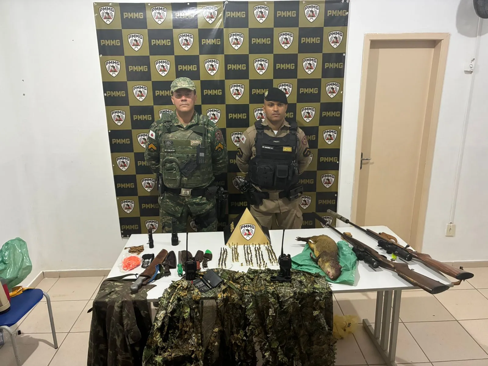 Paca abatida, rifle calibre 22 com silenciador, munições e facas apreendidos pela polícia em operação contra caça ilegal em Buritizeiro.