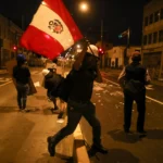 Multidão em comício político no Peru com bandeiras peruanas